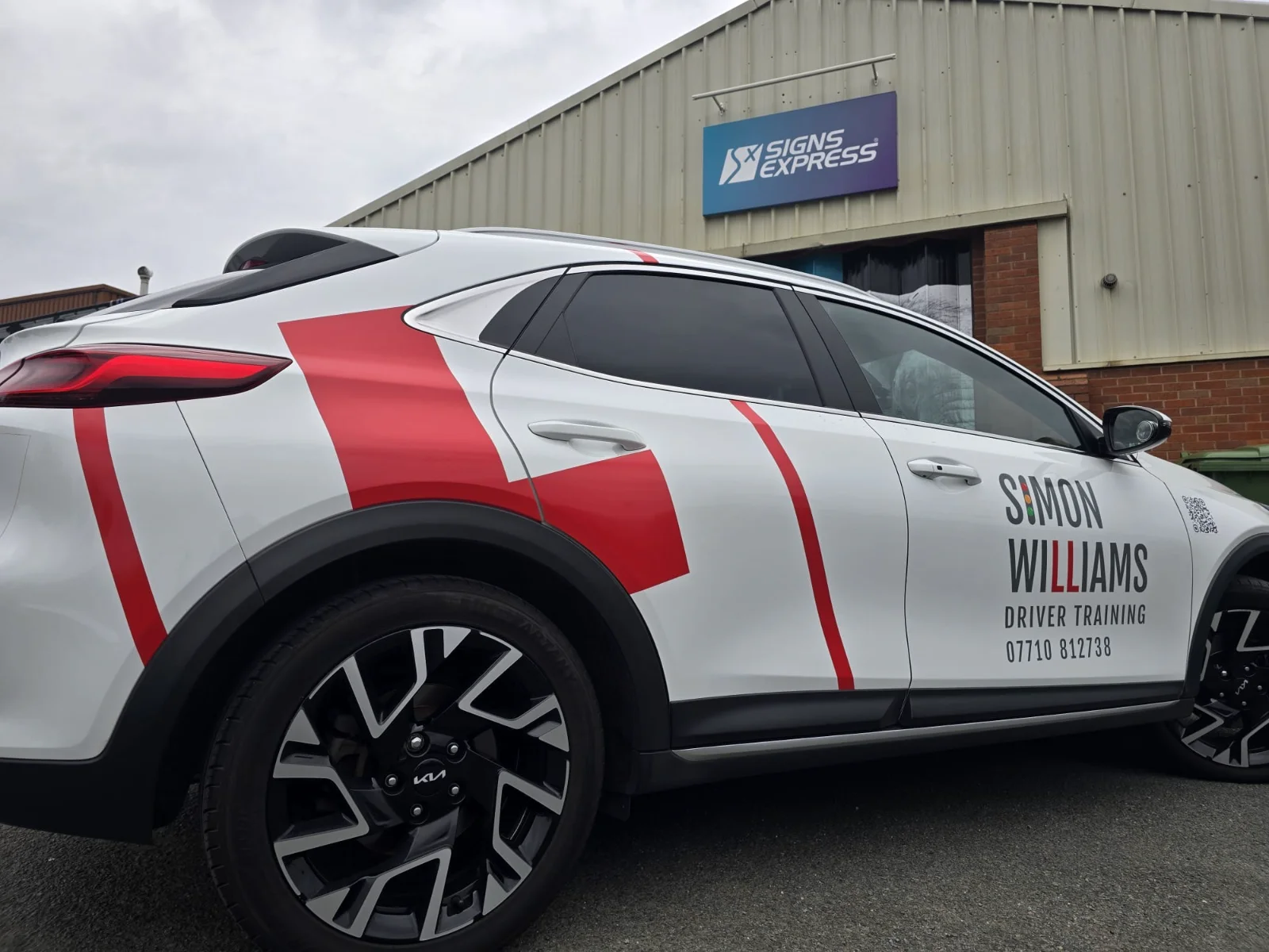 Simon Williams Driver Training’s white teaching car with red learner L graphics and the business name on the doors.